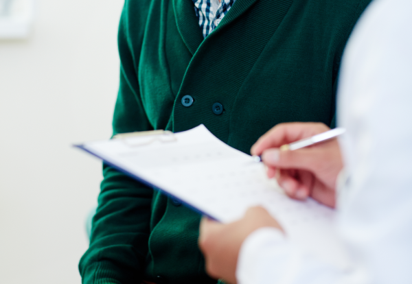 Person signing a document with a pen.